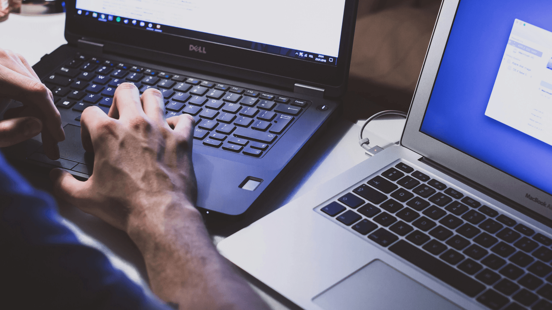 A man working on two laptops