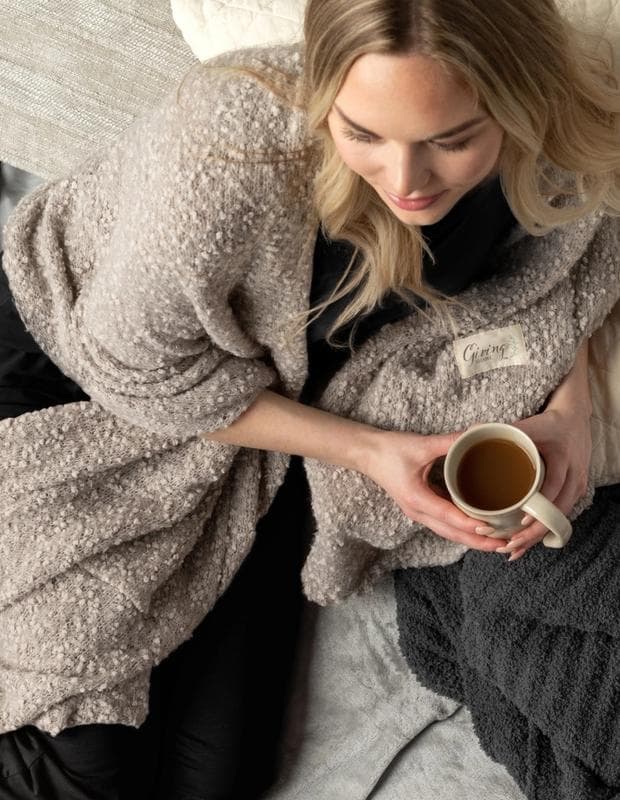 Woman drinking coffee with Demdaco products