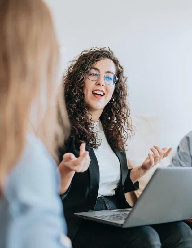 Woman casually speaking with computer on lap