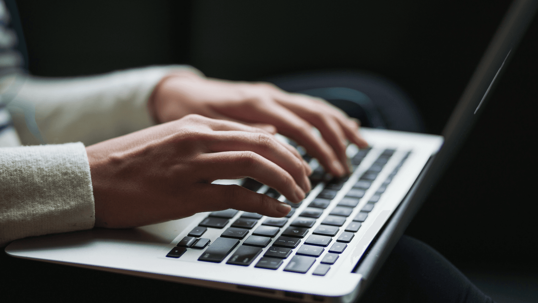 Fingers typing on a laptop