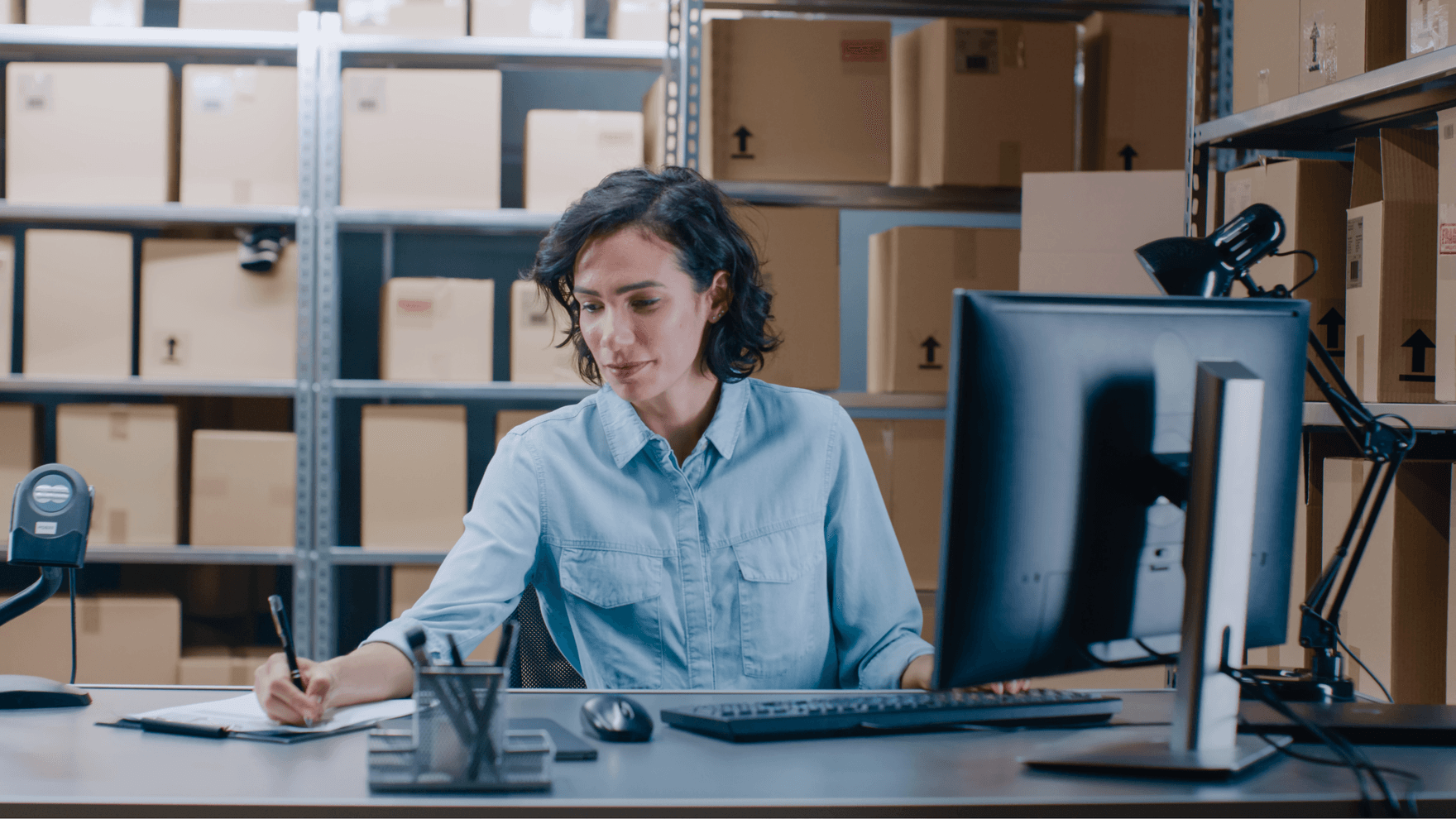 woman working at a desktop in a warehouse