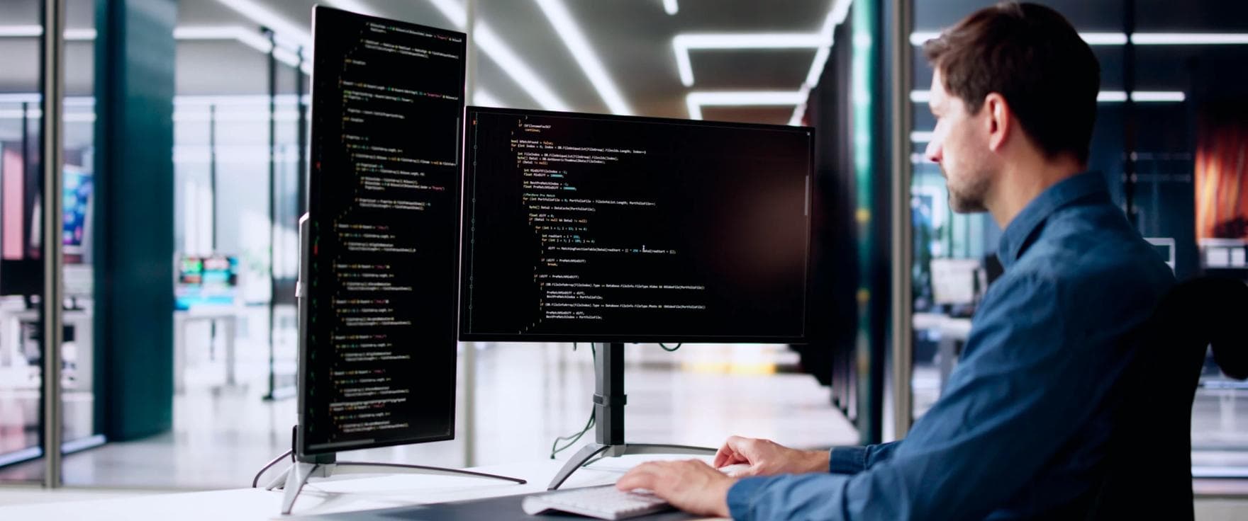 Developer in office working with two monitors