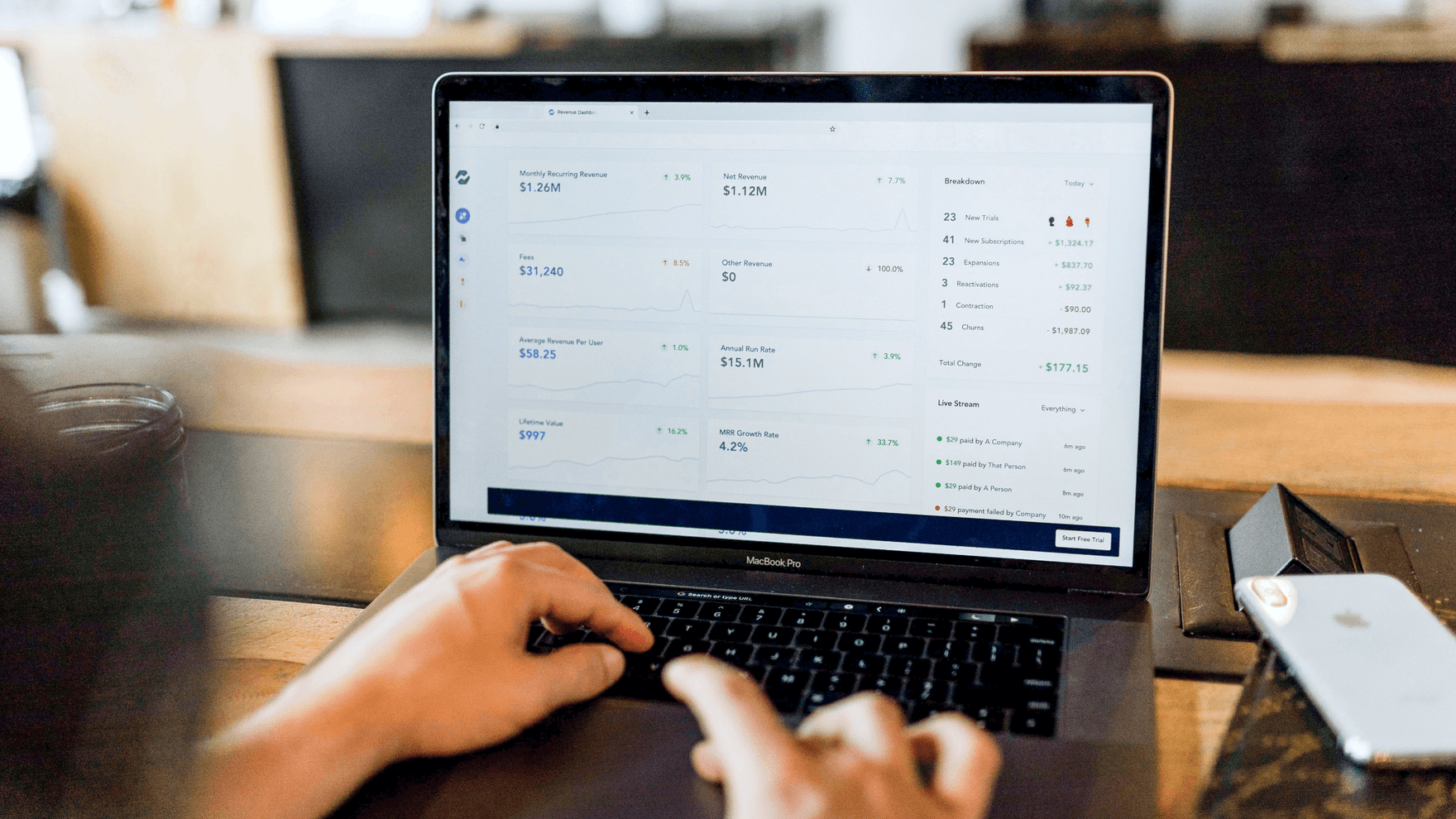 Fingers typing on a laptop, displaying data