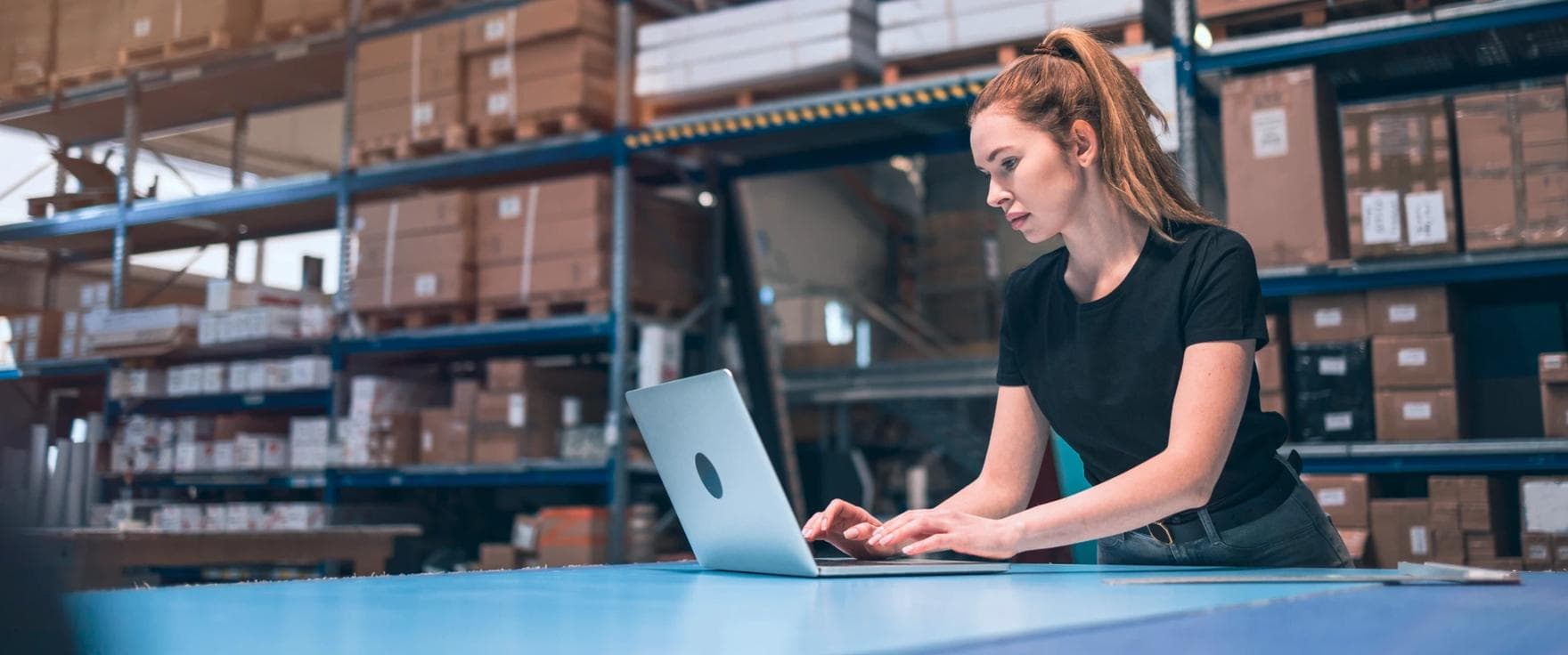 Woman working in eCommerce warehouse with computer