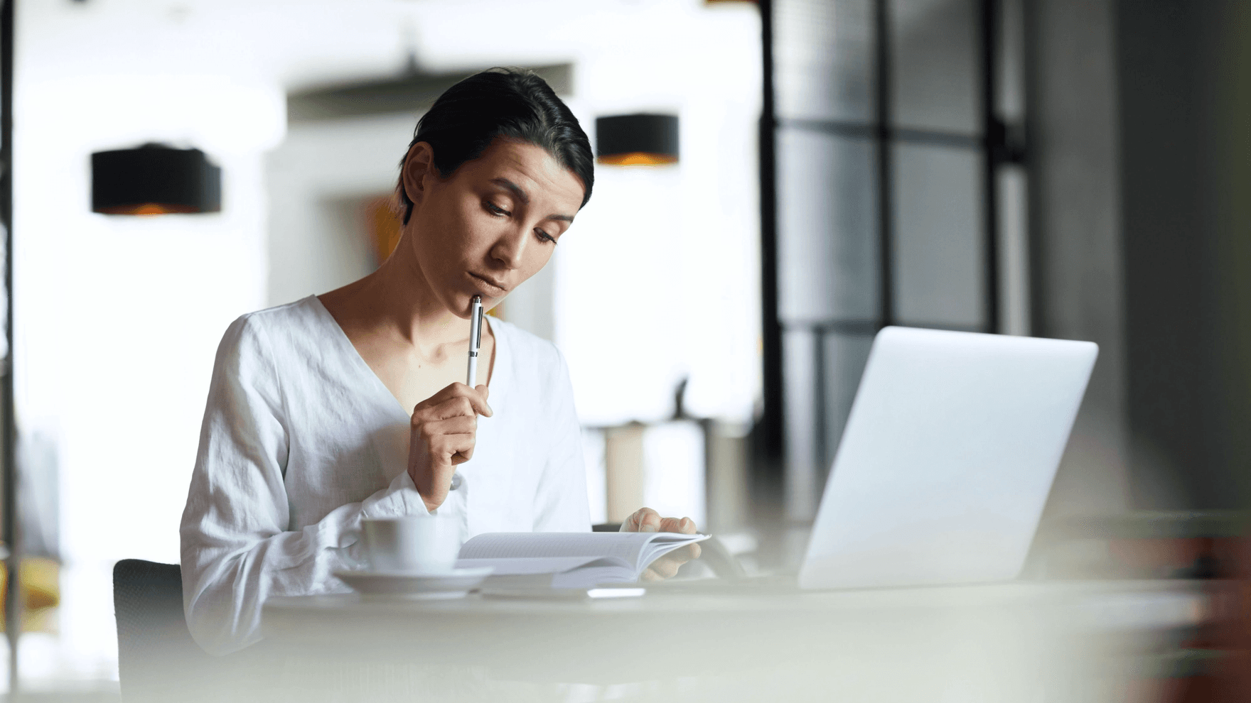 Woman thinking, looking at a notebook