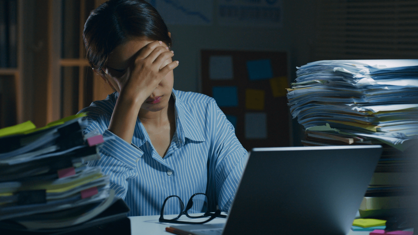 Stressed woman working with papers and computer