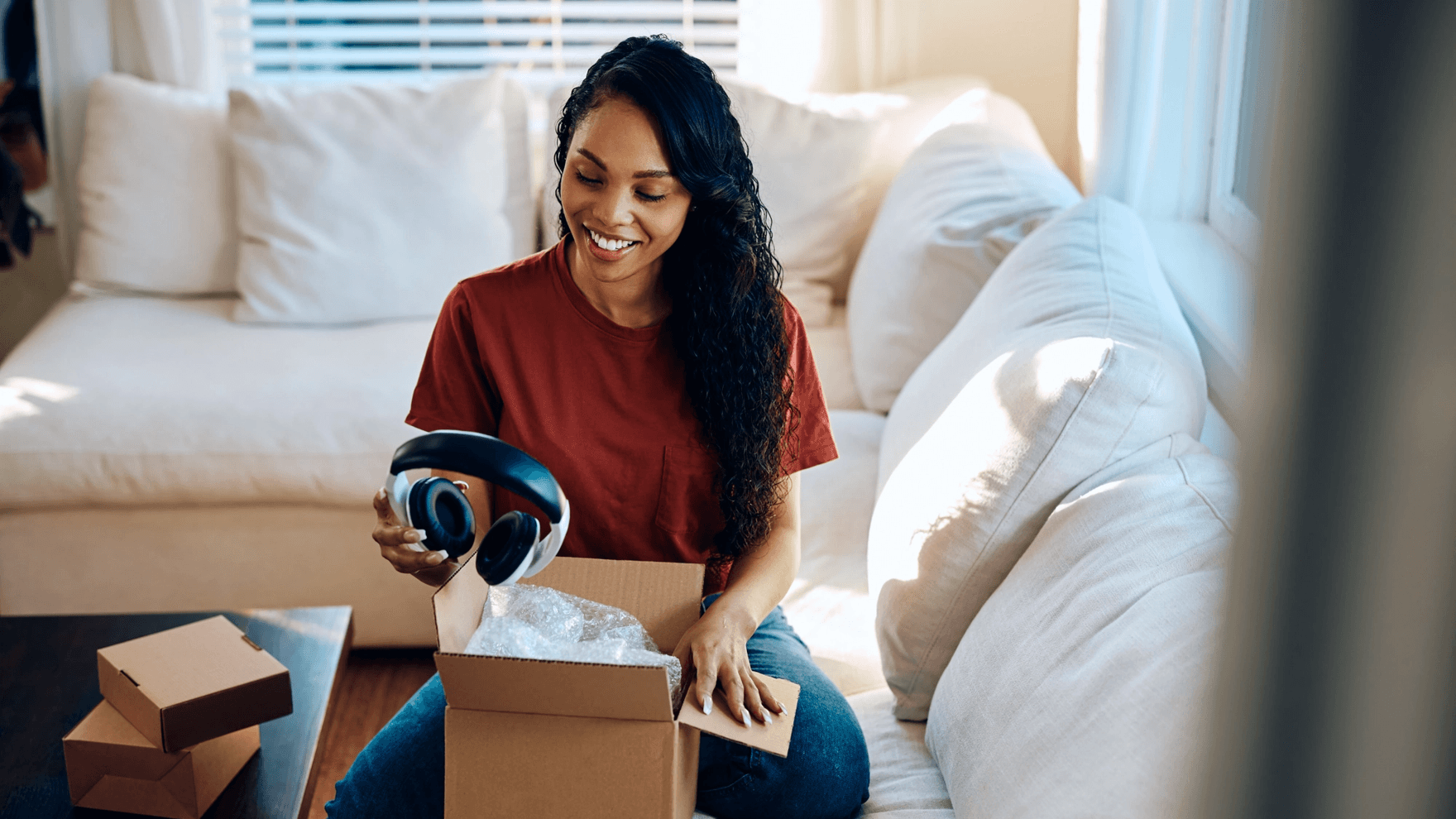 Happy woman unpacks new headphones she bought online.