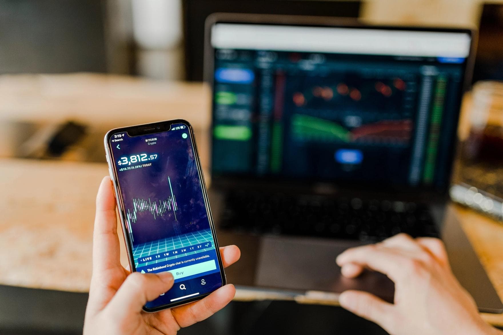 A laptop and smartphone, each displaying financial data.jpg