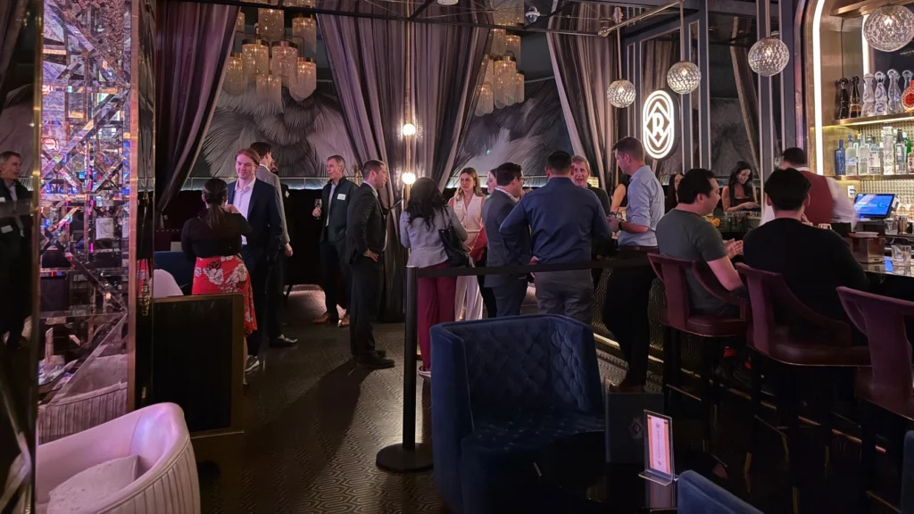 Codl colleagues networking and enjoying drinks at a happy hour gathering in a bar setting.