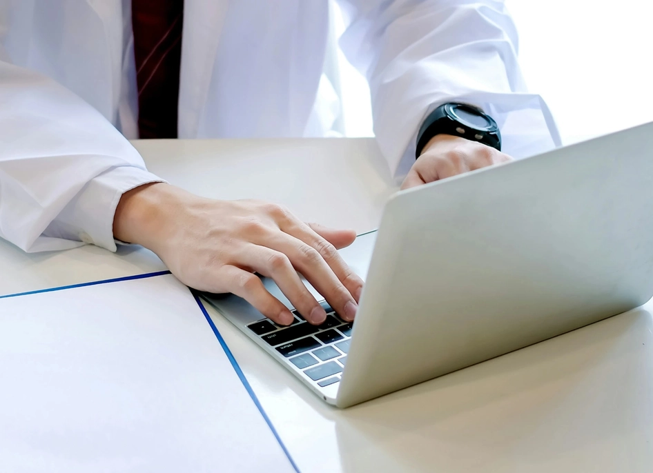 Medical proressional typing on laptop