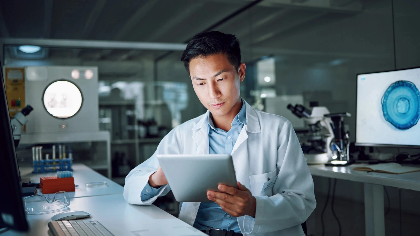 Man working on a iPad in a healthcare or pharma lab