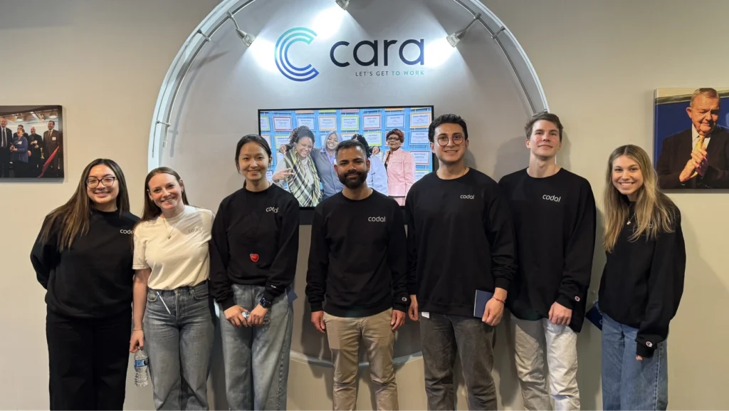 Codal employees gathered in front of the Cara Collective sign during Global Volunteer Month 