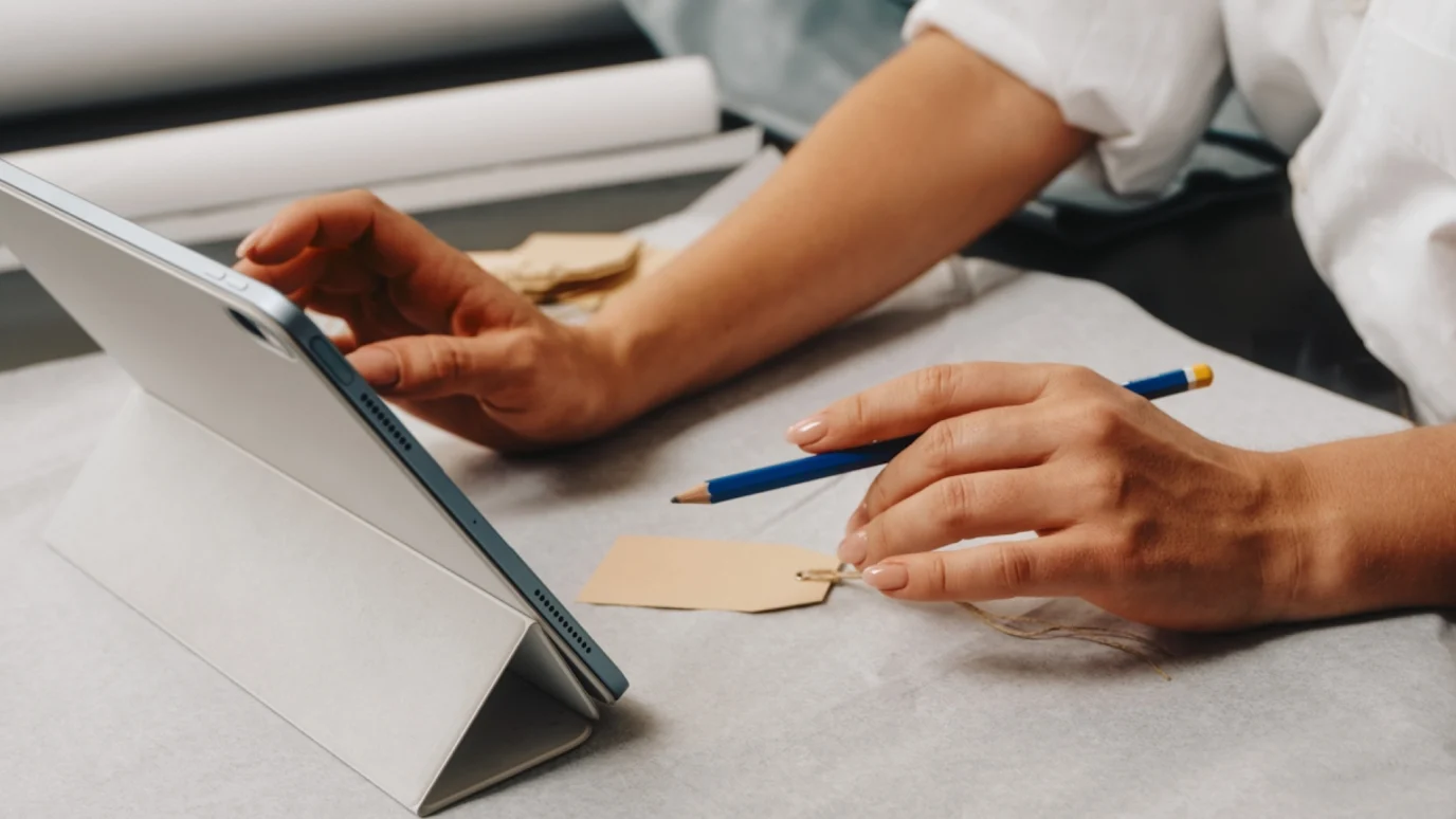 Entrepreneur or founder using a digital tablet for design and planning, emphasizing hands-on brand creation and innovation.