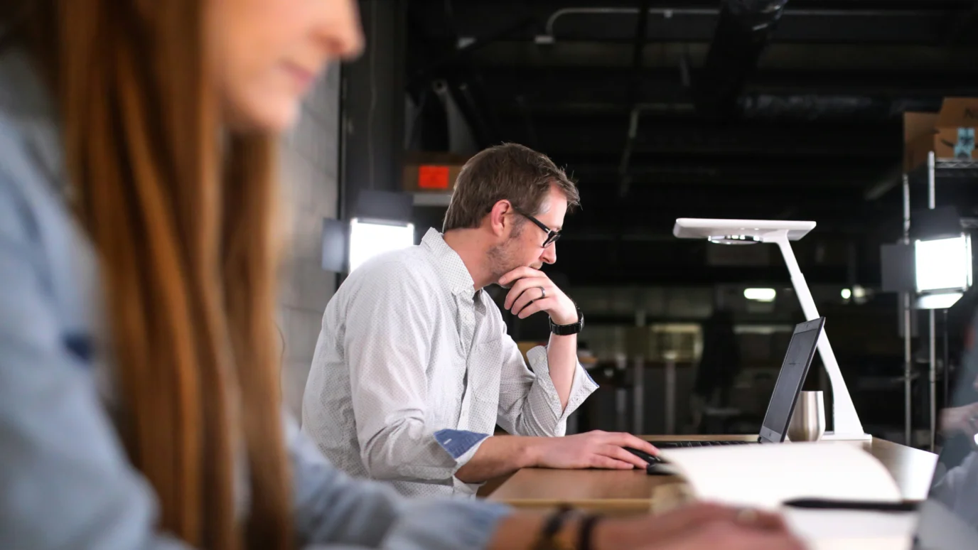 Startup founder or mentor concentrating on a technical task or strategic document on a laptop, emphasizing the dedicated work environment within an accelerator program.