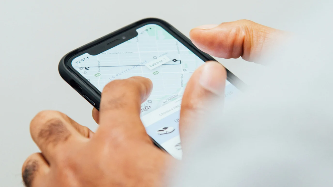 Hands using a mapping application on a smartphone.